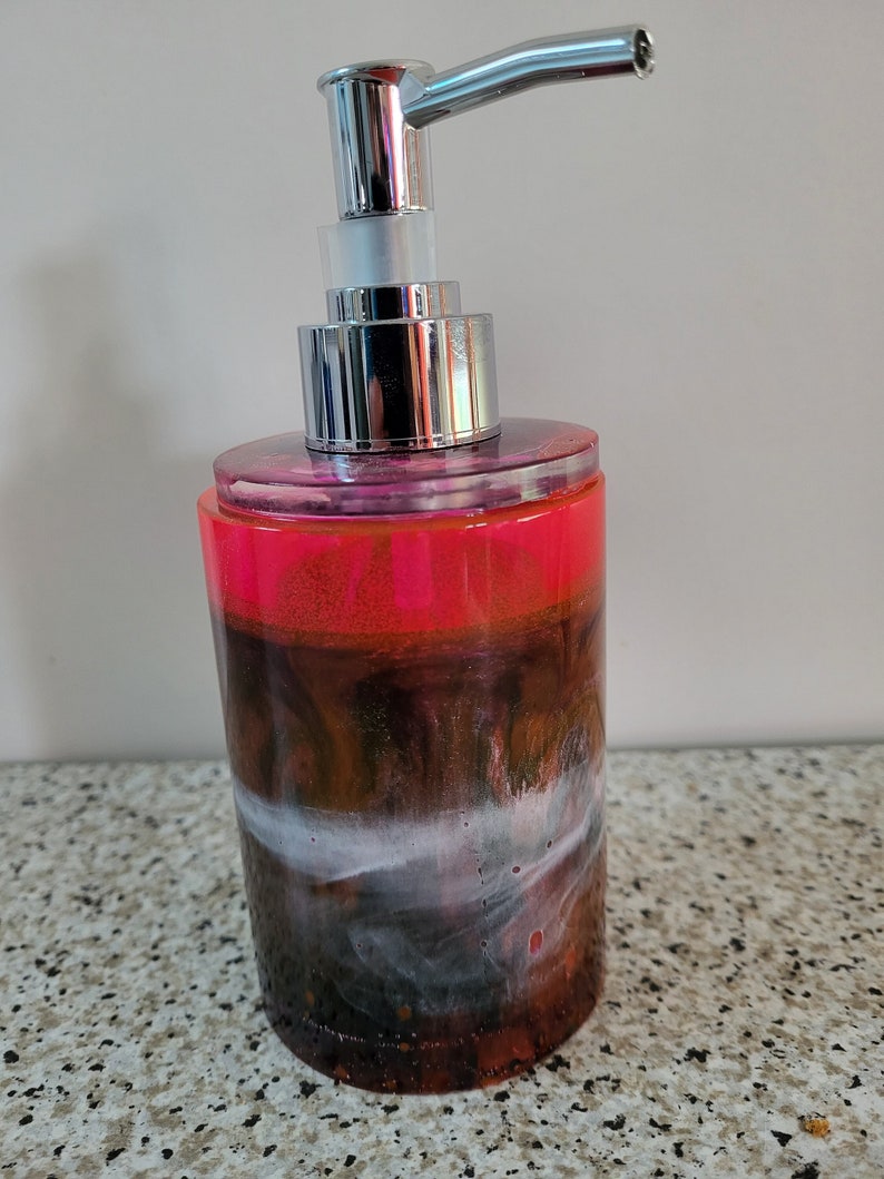 Un distributeur de savon entièrement fait en résine epoxy avec une pompe qui se dévisse facilement pour le remplir à nouveau Rose et noir
