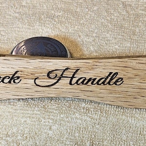 May include: A wooden oven rack handle with the words "Oven Rack Handle" engraved on it.