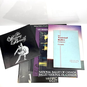 Peut inclure: Une collection de cinq programmes de ballet vintage présentant The Sleeping Beauty, Les Grands et The National Ballet Company of Canada. Les couvertures affichent diverses typographies, des photos de danseurs en noir et blanc et des accents violets et bleus.