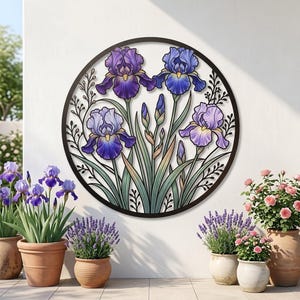 Op de afbeelding: Een cirkelvormig metalen wandkunstwerk met een gedetailleerde illustratie van paarse en blauwe irissen met groene stengels en bladeren. Het ontwerp is gevat in een dunne zwarte cirkelvormige lijst en toont levendige bloemkleuren.