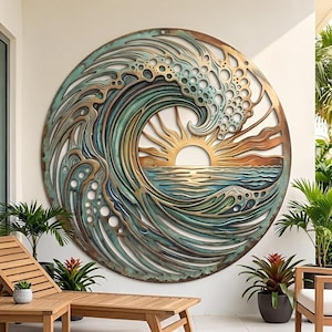 May include: A circular metal wall art piece featuring a layered cutout design of a large ocean wave crashing over a sunrise. The artwork displays a gradient of teal, blue, and bronze tones with intricate cutouts representing sea foam and rays.