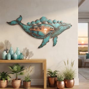 May include: A wall-mounted metal whale sculpture featuring a weathered teal and copper patina finish. The whale's back is adorned with a row of seashell shapes, and its body contains a cutout scene depicting a tropical sunset with palm trees.