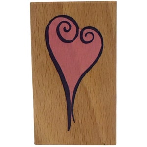May include: A pink heart with a black outline and swirling details painted on a wooden surface.