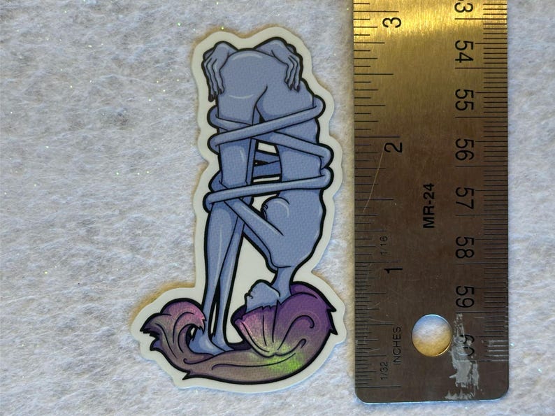 Puede incluir: Una pegatina con una ilustraci&oacute;n estilizada de dos figuras entrelazadas. Las figuras est&aacute;n representadas en tonos azules, con un dise&ntilde;o arremolinado y colorido en la base. La pegatina mide aproximadamente 7,6 cm de altura.