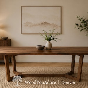 May include: A rectangular dark brown wooden dining table with a thick tabletop and a geometric base featuring angled legs. The table is positioned centrally, displaying a smooth wood grain surface and a sturdy, wide-frame construction.