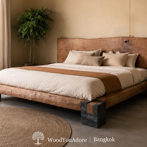 Peut inclure: Un cadre de lit bas en bois naturel avec une tête de lit à bord brut proéminente, doté de supports d'angle en pierre sombre. Le lit est habillé de linge blanc avec un chemin de lit marron et plusieurs oreillers beiges, avec le texte WoodYouAdore Bangkok.