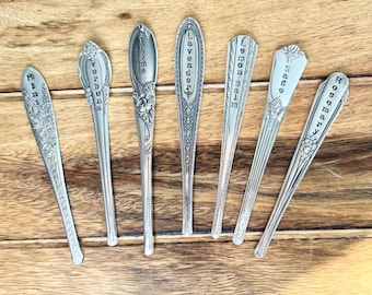 May include: Seven silver spoons with engraved names of herbs: Mint, Verbena, Thyme, Lavender, Lemon Balm, Sage, and Rosemary.