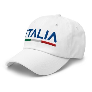 May include: White baseball cap with the word "ITALIA" embroidered in blue with a green, white, and red stripe underneath.