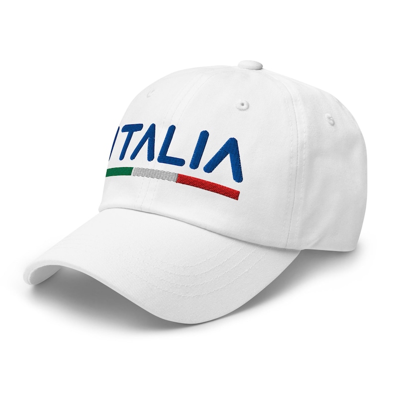 May include: White baseball cap with the word "ITALIA" embroidered in blue with a green, white, and red stripe underneath.