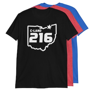May include: Black t-shirt with a white outline of the state of Ohio and the text "C-LAND 216" inside. The shirt is shown with two other t-shirts in red and blue.