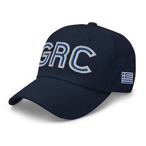 May include: A navy blue baseball cap with the letters "GRC" embroidered in white with a blue outline. The Greek flag is embroidered on the right side of the cap.