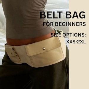 May include: A beige belt bag featuring two front pockets with silver-tone snap closures. The text on the image reads: BELT BAG FOR BEGINNERS SIZE OPTIONS: XXS-2XL. The bag is worn around the waist over dark trousers and a grey top.