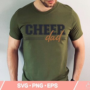 May include: A green t-shirt with the text "CHEER dad" in black and orange lettering.