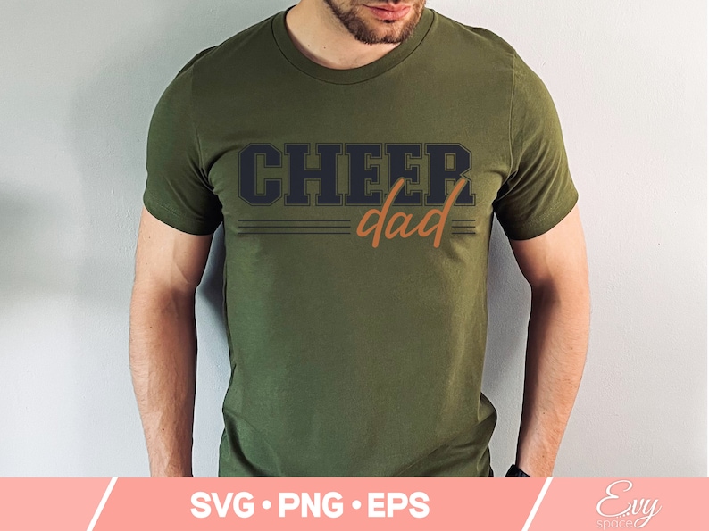 May include: A green t-shirt with the text "CHEER dad" in black and orange lettering.