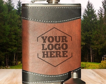 May include: A stainless steel flask with a brown leather-like front panel and black accents. The flask features the text "YOUR LOGO HERE" within a hexagon shape. A small metal funnel sits beside the flask.