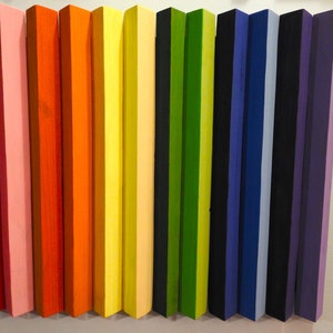 May include: A set of 15 wooden blocks painted in a rainbow color scheme, starting with red and ending with purple. The blocks are arranged in a row, with the red block on the left and the purple block on the right.