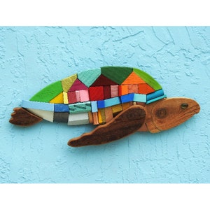 May include: A colorful wooden turtle sculpture with a mosaic shell made of various colored wood pieces. The turtle is swimming in a blue water background.