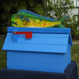 May include: A blue wooden mailbox with a red flag and a painted yellow and green fish on top.