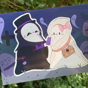 May include: A black and white illustration of two cartoon characters dressed as a grim reaper and a ghost. The grim reaper is wearing a top hat and a purple bow tie. The ghost is wearing a pink bow and carrying a small brown bag. The characters are standing in a graveyard with tombstones that say "RIP".