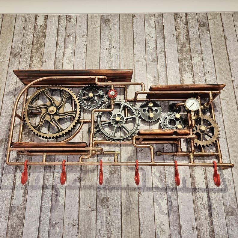 May include: A steampunk-style wall shelf with copper-colored pipes, wooden shelves, and decorative gears. The shelf features six red hooks and a pressure gauge. The design incorporates industrial and vintage elements.