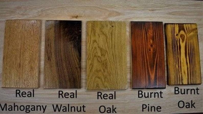 May include: Five wood samples, each labeled with the type of wood. The samples are arranged from left to right: Real Mahogany, Real Walnut, Real Oak, Burnt Pine, Burnt Oak.