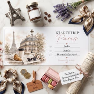 May include: A gift certificate for a trip to Paris, with a watercolor illustration of the Eiffel Tower and Parisian buildings. Includes a box of macarons, a luggage tag, a miniature Eiffel Tower, and a map.
