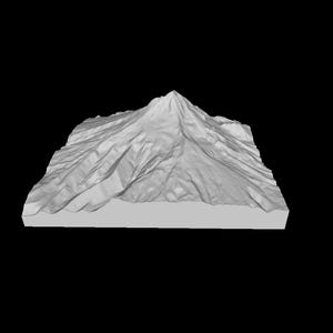 Puede incluir: Un modelo 3D impreso de una montaña con un pico puntiagudo y laderas texturizadas.