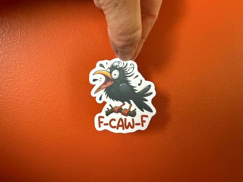 May include: A sticker featuring a cartoon crow with an open beak, perched on a branch. The crow is black with a yellow beak and orange feet. The sticker has the text "F-CAW-F" in red.