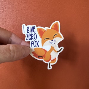May include: A sticker with a cartoon fox smiling and the text "i give zero fox" in blue.