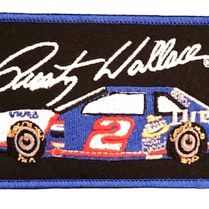 May include: An embroidered patch in black and blue, depicting a racing car with the number 2 and the words "Miller Lite" on the side. The car is set against a black background with the signature "Rusty Wallace" in white above it.