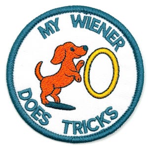 May include: Embroidered patch with a white background, teal border, and text that reads "MY WIENER DOES TRICKS." An orange dachshund dog is jumping through a yellow hoop. A fun, novelty item.
