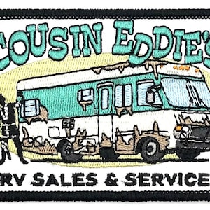 May include: Embroidered patch featuring a cartoon RV with the text "COUSIN EDDIE'S RV SALES & SERVICE" in a white oval.