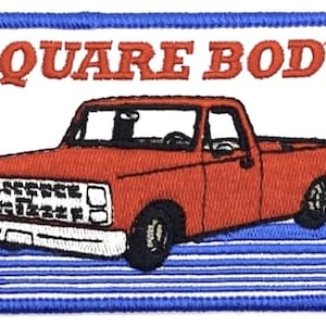 May include: Embroidered patch featuring a red pickup truck with the text "SQUARE BODY" in red letters. The patch has a blue border with white and blue stripes.