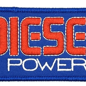 Peut inclure: Un patch rectangulaire bleu avec des coutures blanches autour des bords. Le patch a les mots "DIESEL POWER" brodés en lettres blanches et rouges.