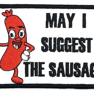 Könnte beinhalten: Ein weißer gestickter Aufnäher mit einer Cartoon-Wurstfigur, die einen Daumen nach oben zeigt. Der Text auf dem Aufnäher lautet "May I suggest the sausage?"
