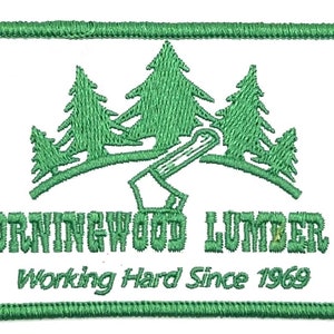 May include: Green embroidered patch with a white background. The patch features three stylized pine trees, an axe, and the text "Morningwood Lumber Co. Working Hard Since 1969".