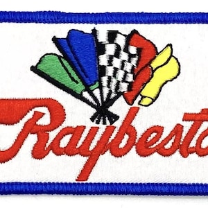 Può includere: Una toppa ricamata bianca con un bordo blu. La toppa presenta una bandiera a scacchi rosso, bianco e blu con un ventaglio di bandiere rosso, bianco e blu dietro. Il testo "Raybestos" è in lettere corsive rosse.