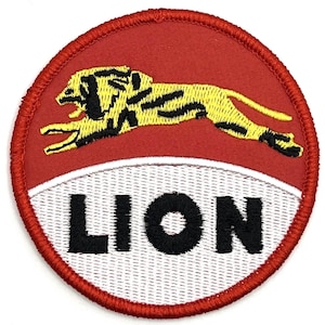 May include: A red and white circular patch with a yellow lion in the center and the word "LION" in black lettering below the lion.