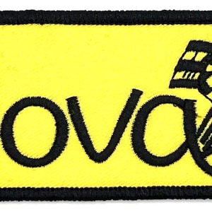 Peut inclure: Écusson brodé jaune avec des points de couture noirs. L'écusson présente le mot "Nova" dans une police de caractères stylisée et un motif de drapeau à damier.