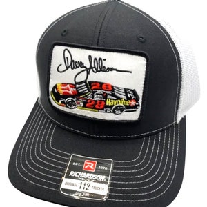 May include: A black and white trucker hat with a black and red embroidered patch featuring a race car with the number 28 and the text "Havoline" and a signature that says "Dave Allen". The hat has a white mesh back and a black front with a white stitched border. The hat has a label that says "Richardson" and "Original 112 Trucker".