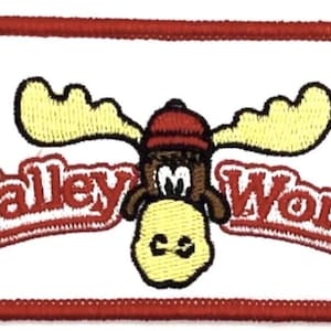 May include: Embroidered patch featuring a cartoon moose wearing a red hat, with yellow antlers and a yellow face. The patch has the words "Walley World" in red script, outlined in white, on a white background with a red border.