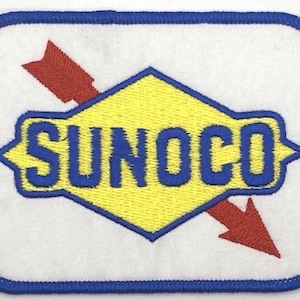 Pode incluir: Patch bordado com o logotipo da Sunoco. O patch tem um fundo branco e uma borda azul. O logotipo inclui a palavra "SUNOCO" em azul, sobre um losango amarelo, com uma seta vermelha a atravessá-lo.