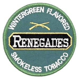 Puede incluir: Un parche circular con fondo verde y borde cosido verde. El parche presenta las palabras "WINTERGREEN FLAVORED" y "SMOKELESS TOBACCO" en blanco, con "RENEGADES" en un diseño negro y dorado.