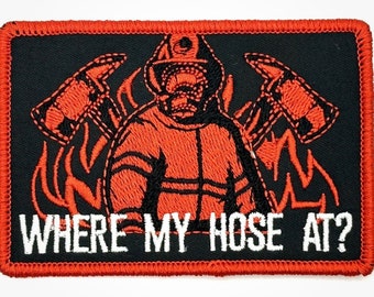 May include: An embroidered patch with a firefighter in an orange uniform holding an axe. The firefighter is surrounded by flames and the text "WHERE MY HOSE AT?" is written in white below the image.