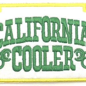 May include: A white embroidered patch with a yellow border. The patch features the text "CALIFORNIA COOLER" in green lettering with a stylized "C" on either side of the word "COOLER".