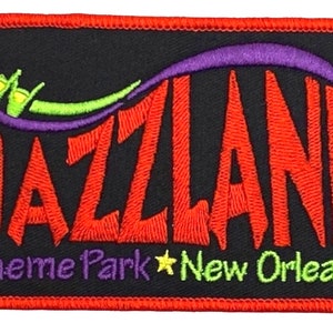 Puede incluir: Un parche bordado rojo, morado y verde con el texto "Jazzland Theme Park New Orleans".
