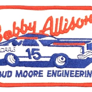 May include: White embroidered patch with a red border. The patch features a white race car with blue and red details, the number 15, and the text "Bobby Allison" and "Bud Moore Engineering".