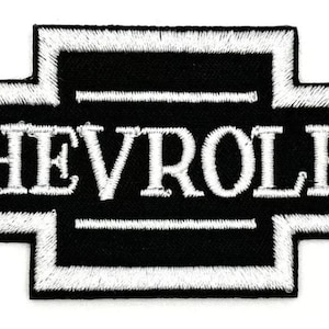 Può includere: Toppa ricamata in bianco e nero con il logo Chevrolet. Il logo è un papillon bianco con la parola "CHEVROLET" in lettere bianche.