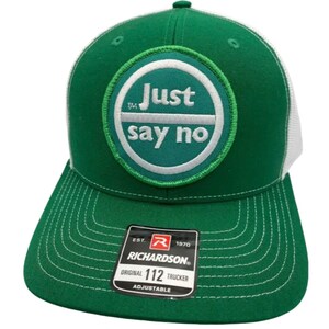 May include: Green and white trucker hat with a white circle patch that says "Just say no" in green letters. The hat is adjustable and has a Richardson 112 label.