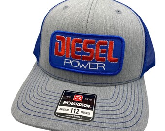 May include: Gray and blue trucker hat with a blue patch that says "Diesel Power" in red and white letters. The hat has a black mesh back and an adjustable strap with the Richardson logo and "Original 112 Trucker" text.